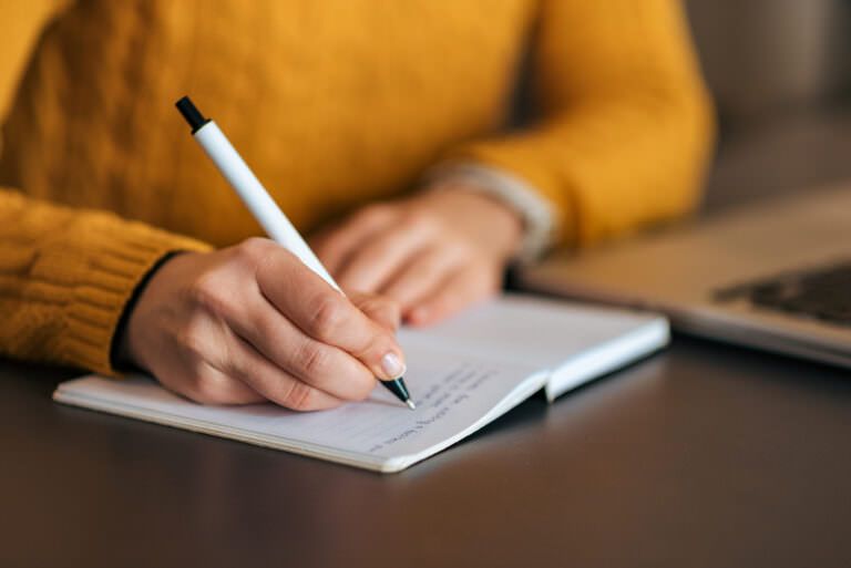 Writing in notebook, close-up