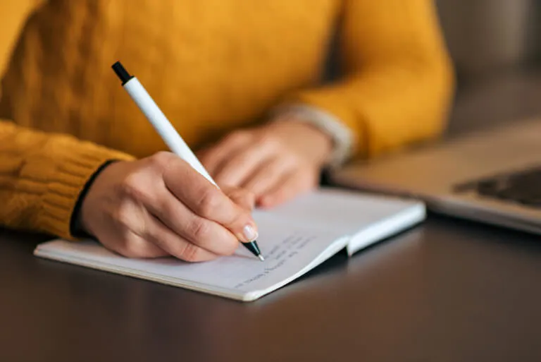 Writing in notebook, close-up