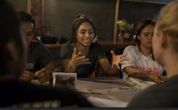 Young woman talking amongst friends.
