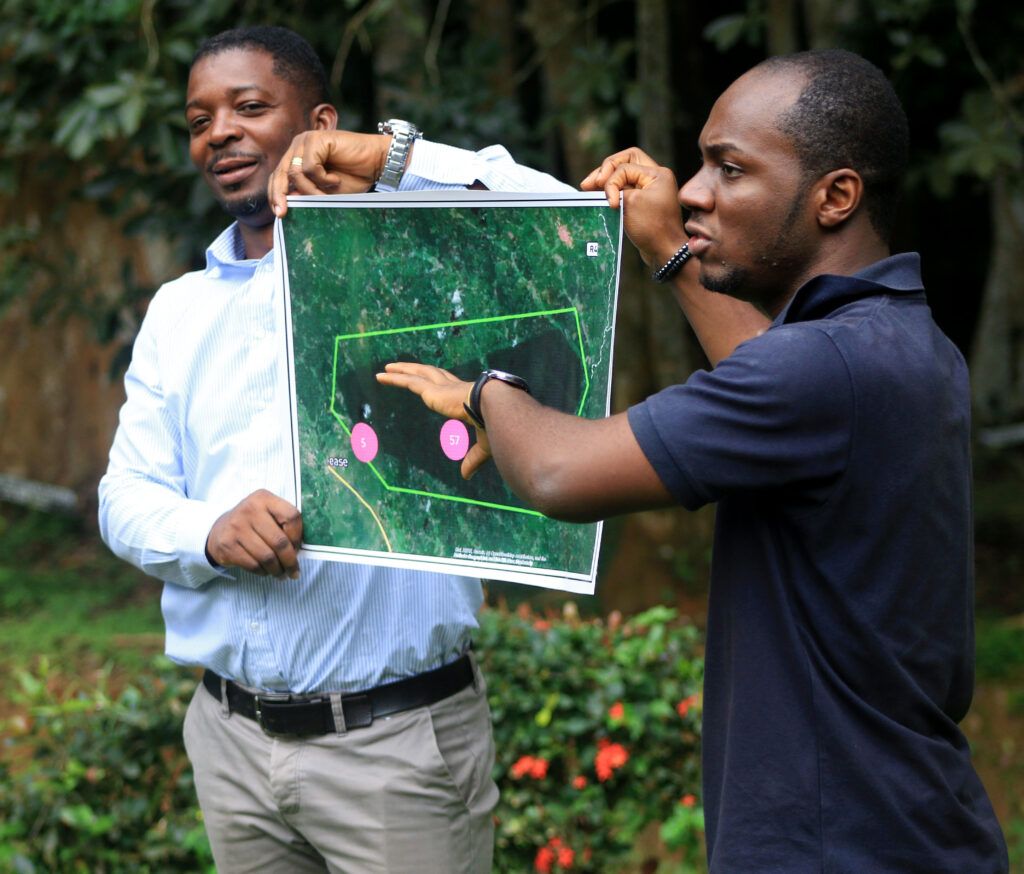 Kwame Osei tient une carte entre ses mains lors d’une démonstration sur le terrain au Ghana