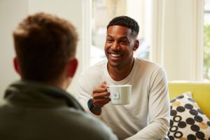 Man smiles while holding a cup of Rainforest Alliance certified tea