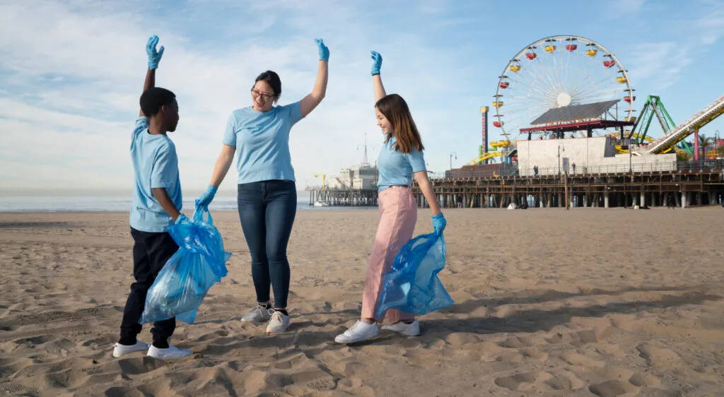 Teacher and students cleaning beach