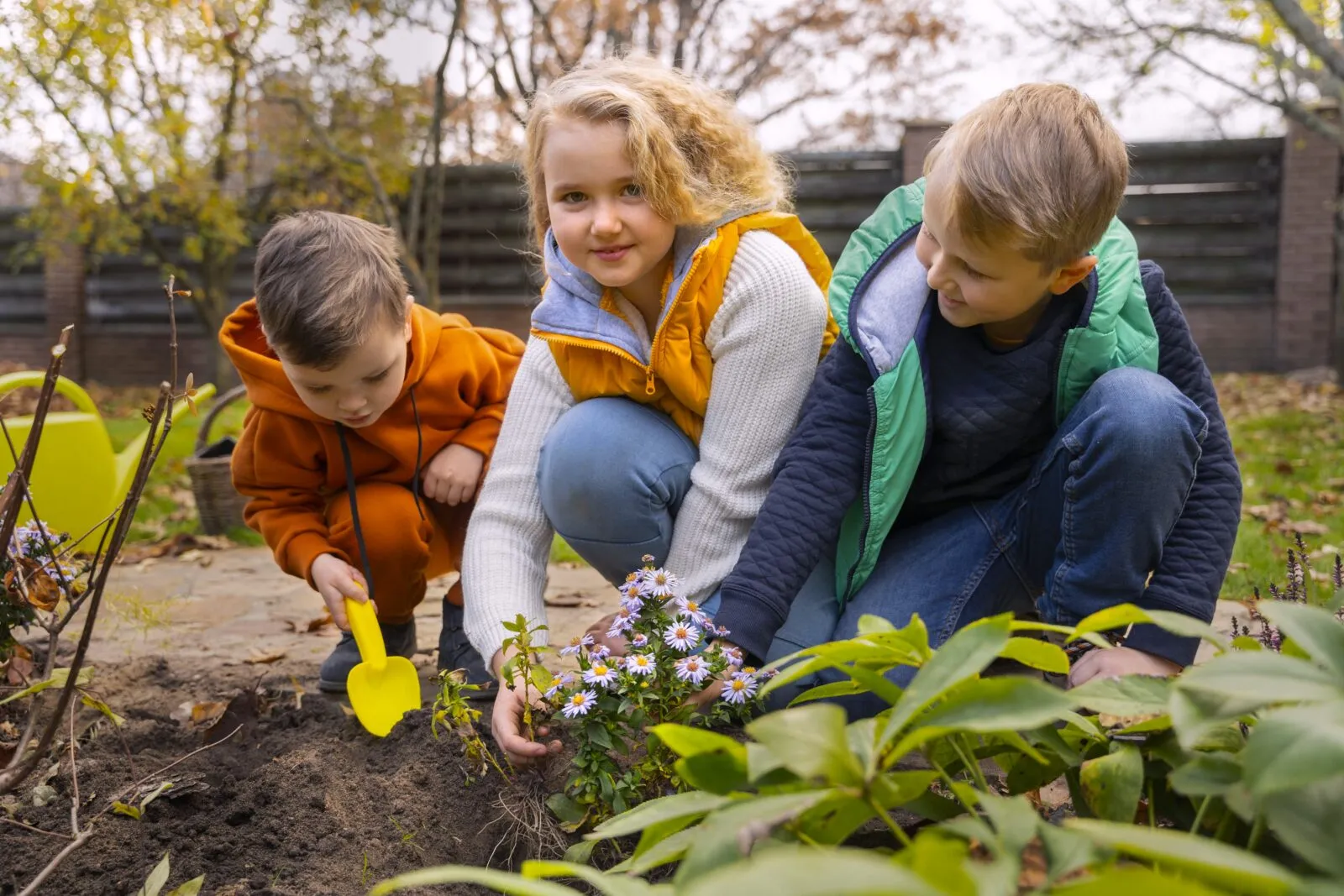 Children planting flowers and smiling